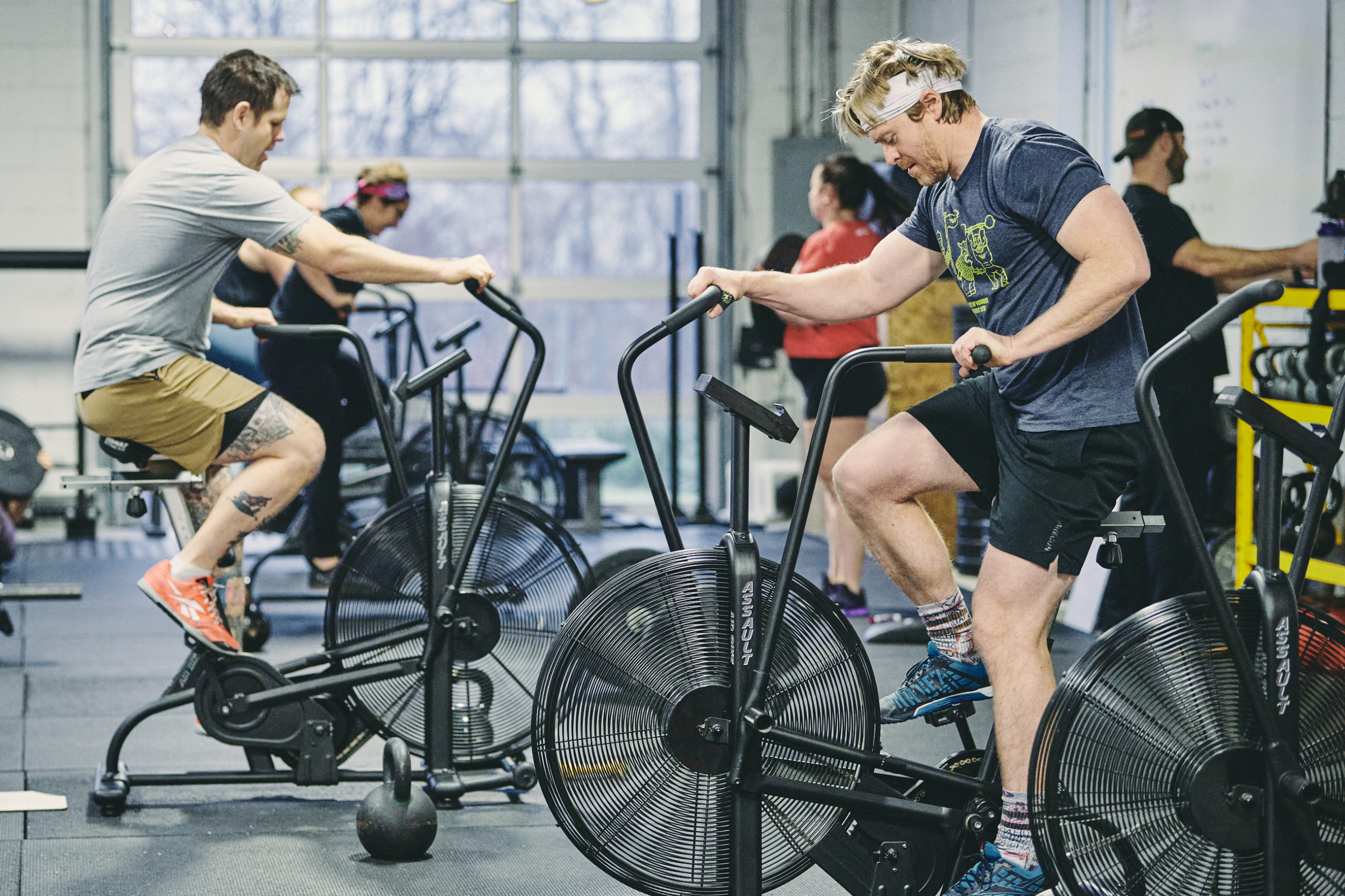 A group of people riding stationary bikes in a gym.