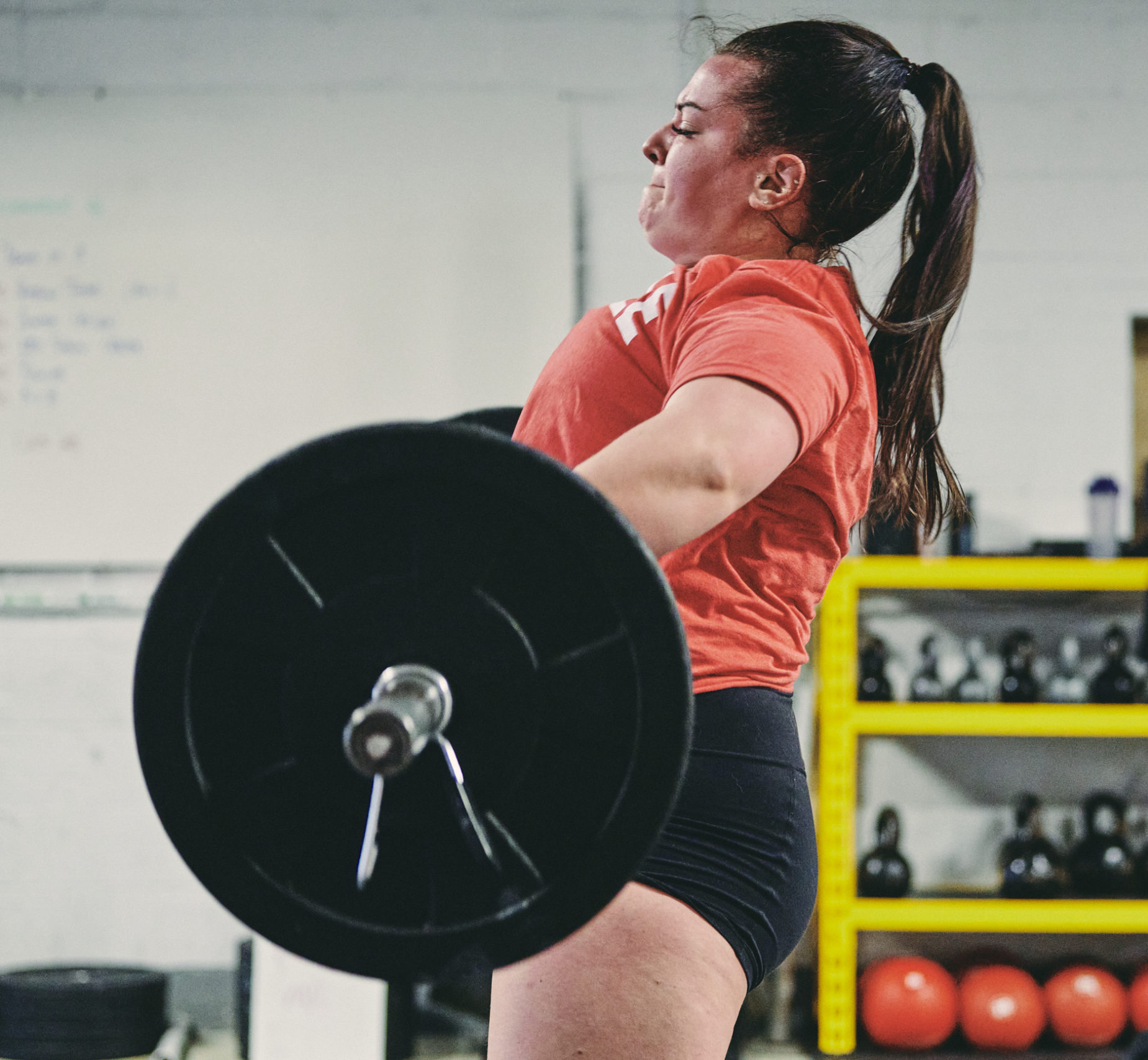 A woman is lifting a barbell in the gym.