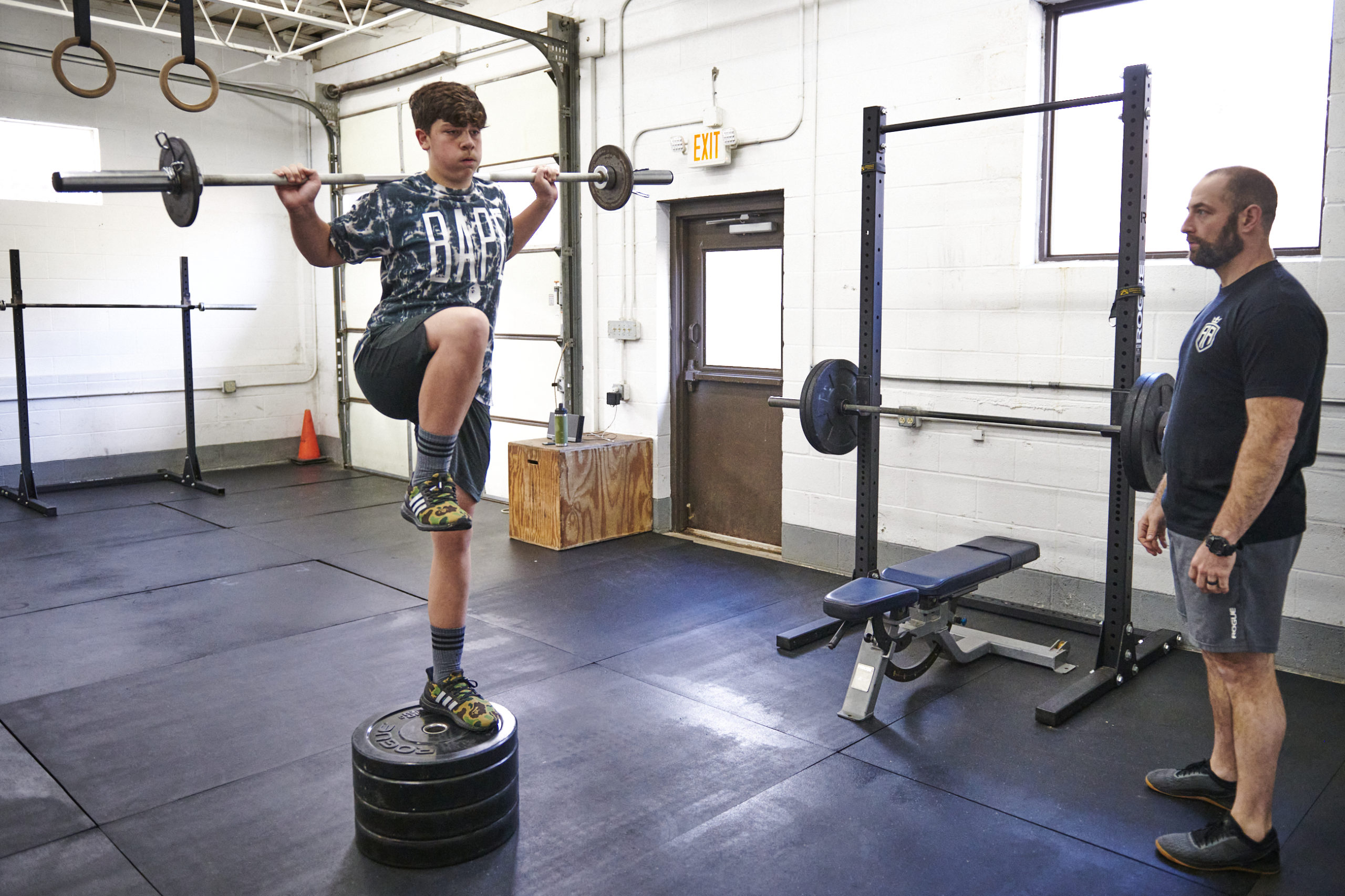 A man is doing squats on a platform