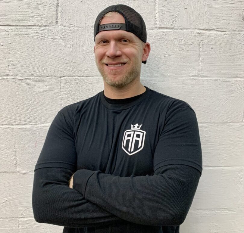 A man standing in front of a wall wearing a headband.